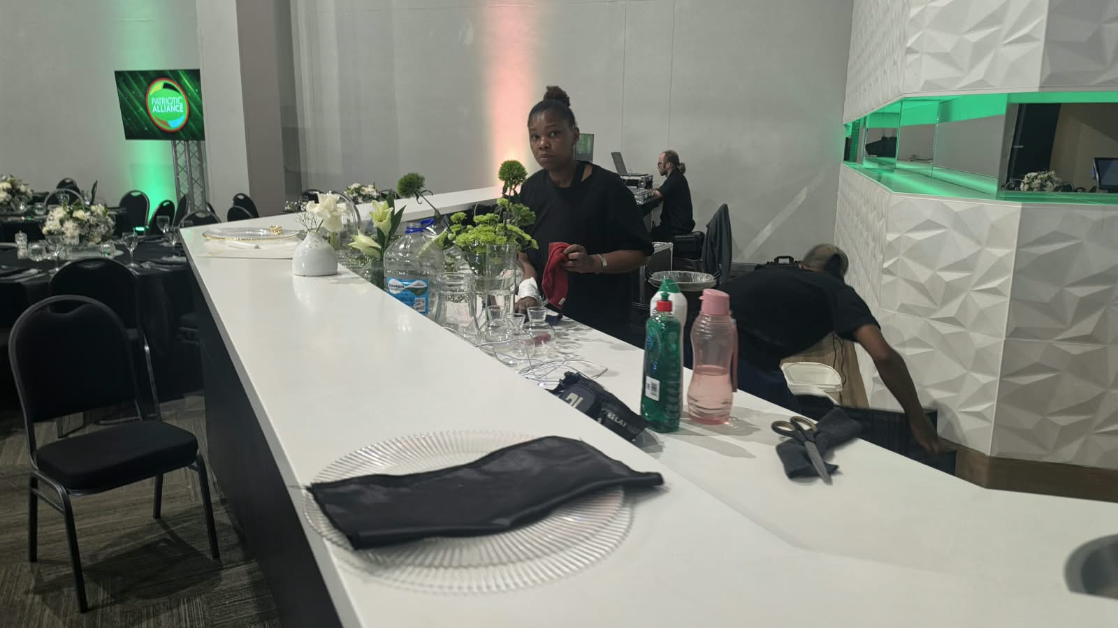 Mobile bar counter with glassware, florals and event crew preparing service